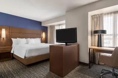 a hotel room with a bed and a flat screen tv at Residence Inn Deptford in Almonesson