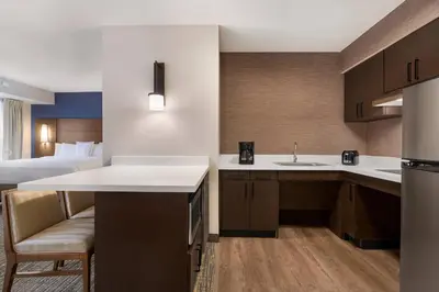 a kitchen with a sink and a room with a bed at Residence Inn Deptford in Almonesson