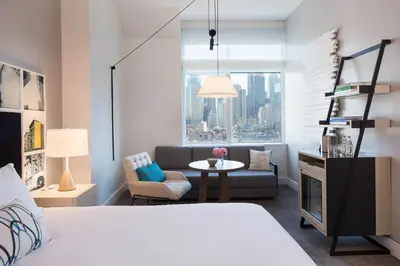 a bedroom with a bed and a couch and a table at Ink 48 Hotel in New York