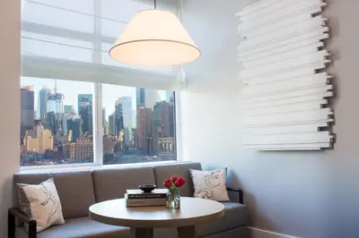 a living room with a couch and a table with a window at Ink 48 Hotel in New York