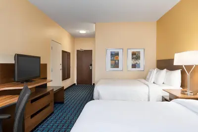 a hotel room with two beds and a flat screen tv at Fairfield Inn by Marriott Deptford in Deptford