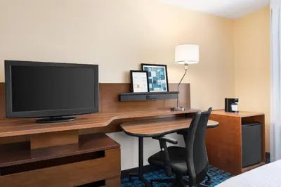 a hotel room with a desk with a television and a chair at Fairfield Inn by Marriott Deptford in Deptford