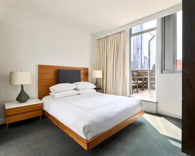 a bedroom with a large bed and a large window at Smyth Tribeca in New York