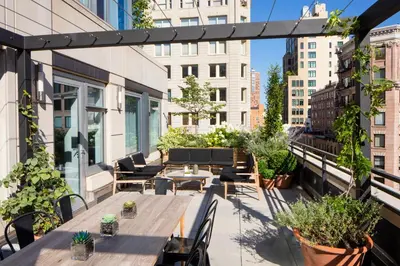 an outdoor patio with tables and chairs and plants at Smyth Tribeca in New York