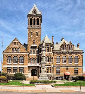a large brick building with a clock tower at City Hall Grand Hotel in Williamsport