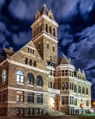 a large brick building with a clock tower on top at City Hall Grand Hotel in Williamsport
