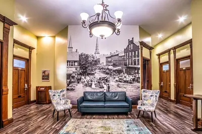 a living room with a couch and chairs at City Hall Grand Hotel in Williamsport