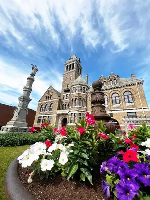 a building with a bunch of flowers in front of it at City Hall Grand Hotel in Williamsport