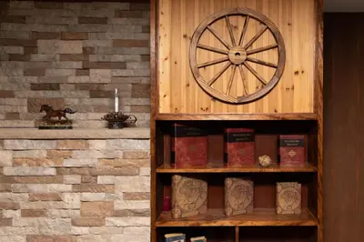 a wooden book shelf with books and a clock at Carriage House Country Club in Pocono Manor