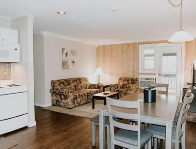 a kitchen and a living room with a table and chairs at Carriage House Country Club in Pocono Manor