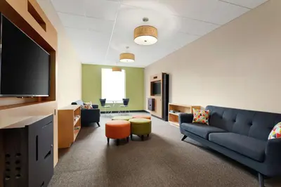 a living room with a couch and a flat screen tv at Home2 Suites by Hilton Middletown in Middletown