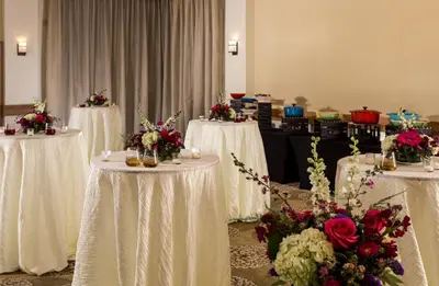 a row of white tables with flowers on them at The Inn At Swarthmore in Swarthmore