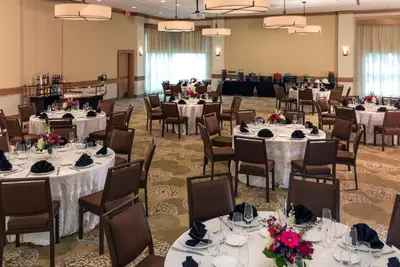 a banquet hall with white tables and chairs at The Inn At Swarthmore in Swarthmore