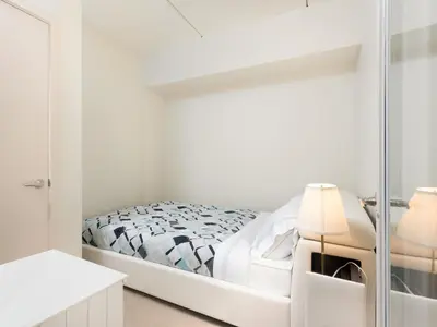 a white bedroom with a bed and a mirror at Fantastic Philly Fully Furnished Apartments in Philadelphia