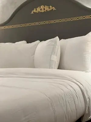 a white bed with white pillows in a bedroom at Chateau Suites in Norristown