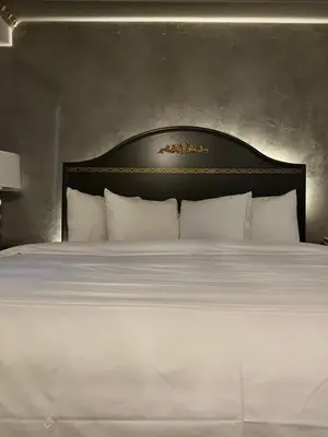 a white bed with a black headboard and white pillows at Chateau Suites in Norristown