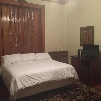 a bedroom with a bed and a television and a window at The Inn at Centre Park in Reading