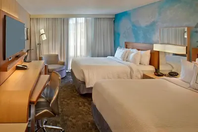 a hotel room with two beds and a desk at Courtyard by Marriott Philadelphia City Avenue in Philadelphia