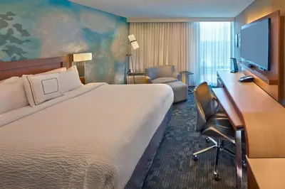 a hotel room with a large bed and a desk at Courtyard by Marriott Philadelphia City Avenue in Philadelphia