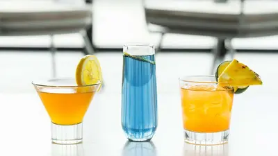 three cocktails sitting on top of a table at Hyatt House Jersey City in Jersey City