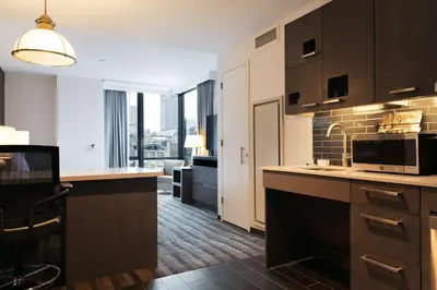 a kitchen with a microwave and a living room at Hyatt House New York/Chelsea in New York