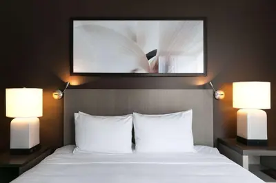 a bed with two lamps and a picture above it at Hyatt House New York/Chelsea in New York