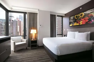 a hotel room with a bed and a chair and a window at Hyatt House New York/Chelsea in New York