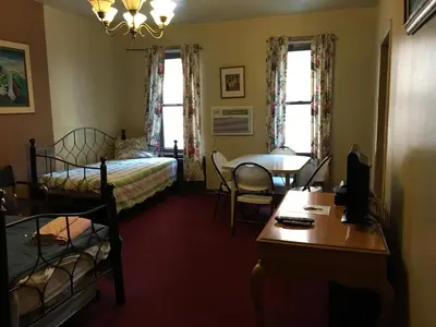a bedroom with two beds and a table and a desk at Beauty Near Times Square in New York