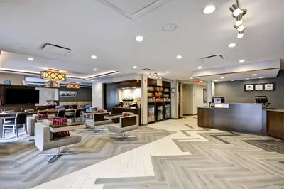 a lobby with a waiting area with chairs and tables at TownePlace Suites by Marriott Dover Rockaway in Dover