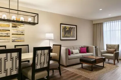 a living room with a couch and a table and chairs at Embassy Suites By Hilton Berkeley Heights in Berkeley Heights