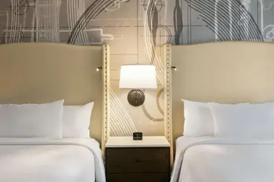 a hotel room with two beds and a lamp at Embassy Suites By Hilton Berkeley Heights in Berkeley Heights