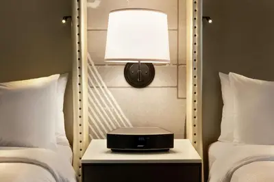 a lamp on a night stand next to two beds at Embassy Suites By Hilton Berkeley Heights in Berkeley Heights