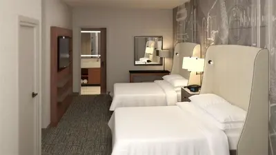 a hotel room with three beds and a television at Embassy Suites By Hilton Berkeley Heights in Berkeley Heights