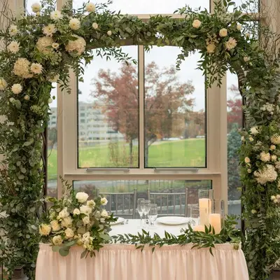 an archway with flowers and a table in front of a window at Embassy Suites By Hilton Berkeley Heights in Berkeley Heights
