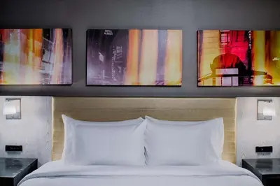 a bedroom with a bed with three paintings on the wall at Doubletree By Hilton New York Times Square West in New York