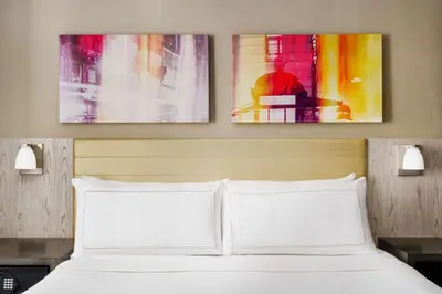 a bedroom with a bed with two paintings on the wall at Doubletree By Hilton New York Times Square West in New York