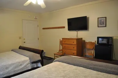 a bedroom with two beds and a flat screen tv at Lakewood Lodge & Restaurant in Lakewood