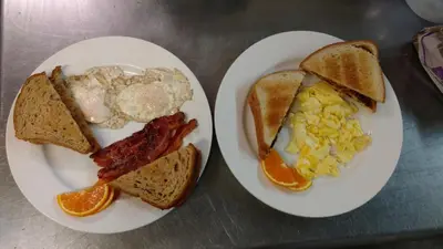 two plates of breakfast food with eggs bacon and toast at Lakewood Lodge & Restaurant in Lakewood