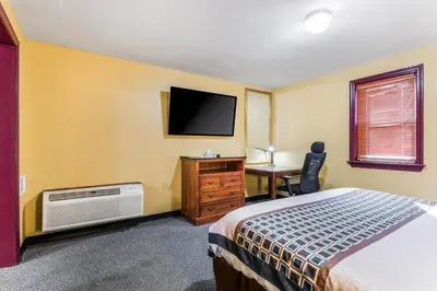 a bedroom with a bed and a desk and a television at Cottage Inn - Grantville in Grantville