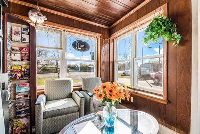 a room with a glass table and chairs and windows at Cottage Inn - Grantville in Grantville