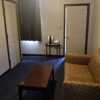 a living room with a couch and a table and a door at Cottage Inn - Grantville in Grantville