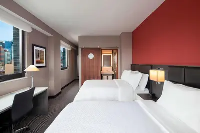 a hotel room with two beds and a red wall at Four Points by Sheraton Manhattan Midtown West in New York