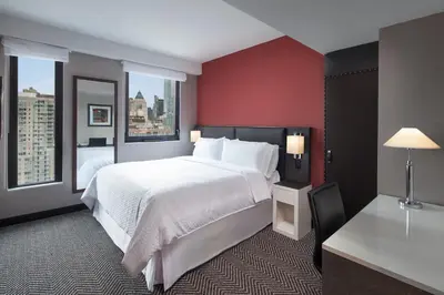 a hotel room with a large bed and two windows at Four Points by Sheraton Manhattan Midtown West in New York