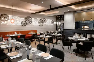 a restaurant with tables and chairs and a bar at LUMA Hotel - Times Square in New York