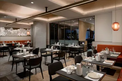 a restaurant with tables and chairs in a room at LUMA Hotel - Times Square in New York