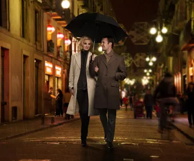 a man and woman walking down a street with an umbrella at LUMA Hotel - Times Square in New York