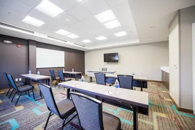 a conference room with tables and chairs and a screen at Residence Inn by Marriott Philadelphia Glen Mills/Concordville in Glen Mills