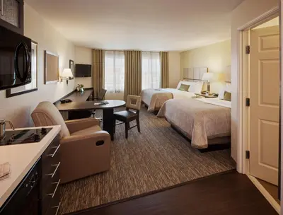 a hotel room with two beds and a desk at Candlewood Suites York by IHG in York