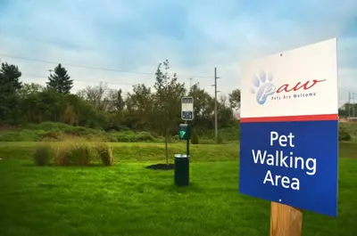 a sign for a pet walking area in a field at Candlewood Suites York by IHG in York