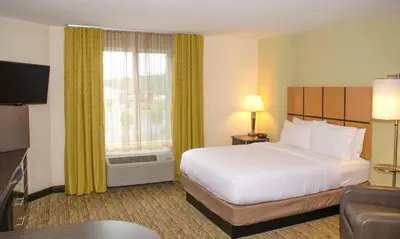 a hotel room with a bed and a large window at Candlewood Suites York by IHG in York